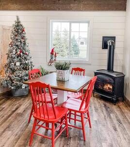 Inside the shop: a flocked tree, red chairs and a wood stove